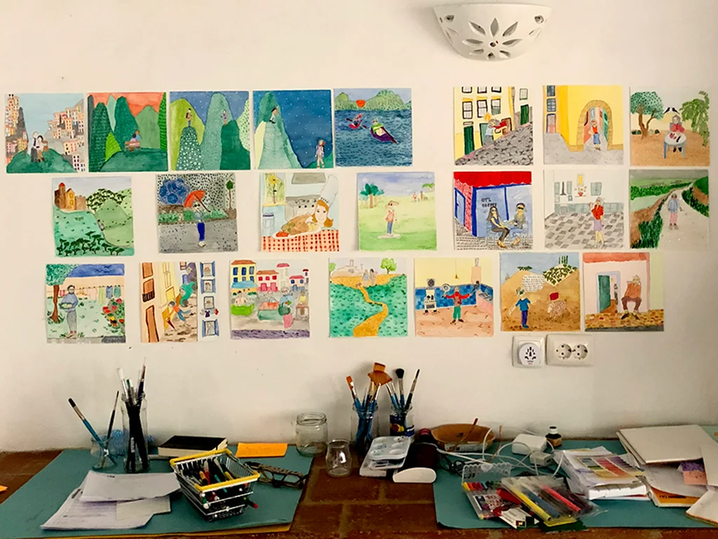 Sketching corner watercolour drawing on wall, table full of color pencils and pinging things