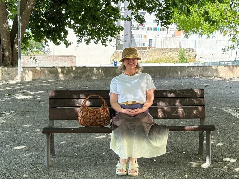 woman wearing a hat sitting on a bench hidden gems in Lisbon