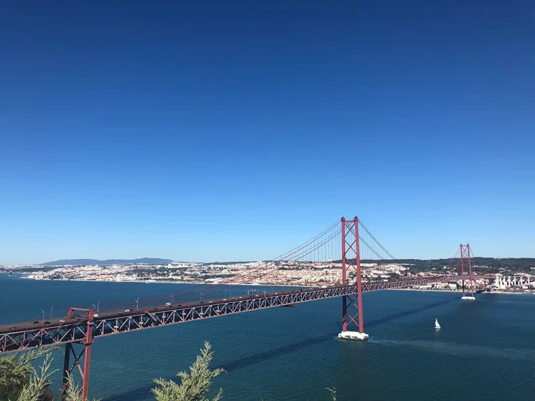 View of Bride 25 de abril in Lisbon, blue sky, calm waters, where to sit in Lisbon