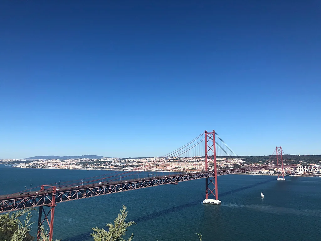 View of Bride 25 de abril in Lisbon, blue sky, calm waters, where to sit in Lisbon
