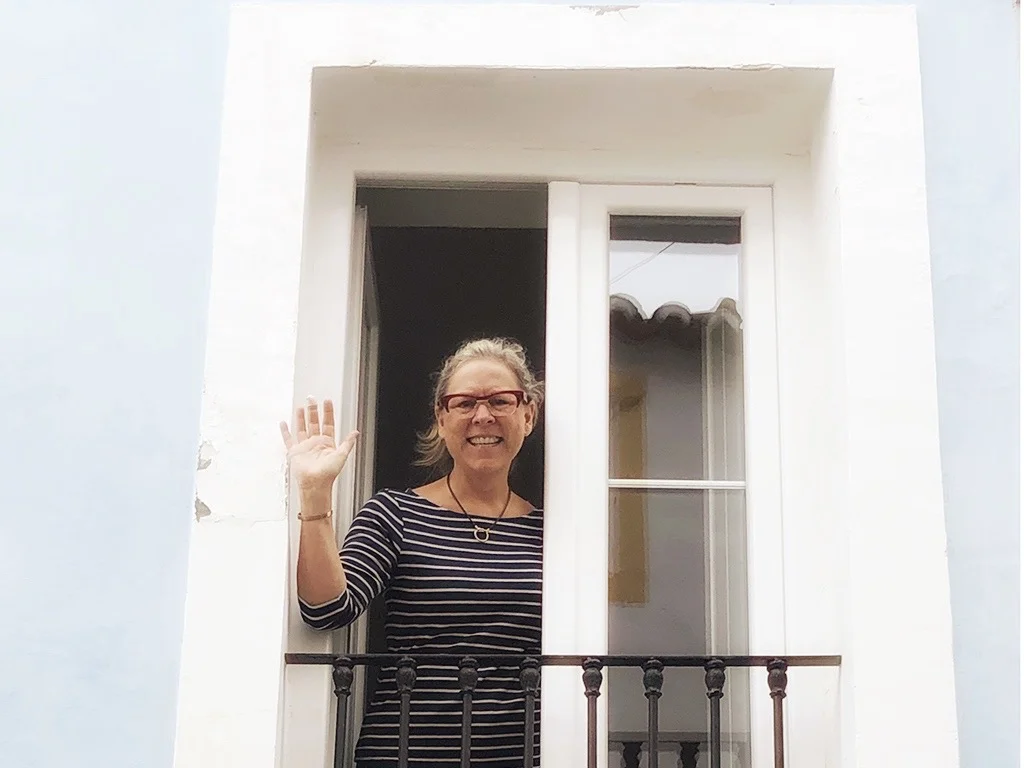My move to Elvas, Alentejo, woman waving from the window, woman wearing glasses
